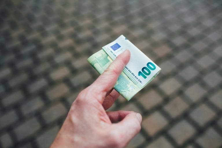 a person holding a piece of money in their hand
